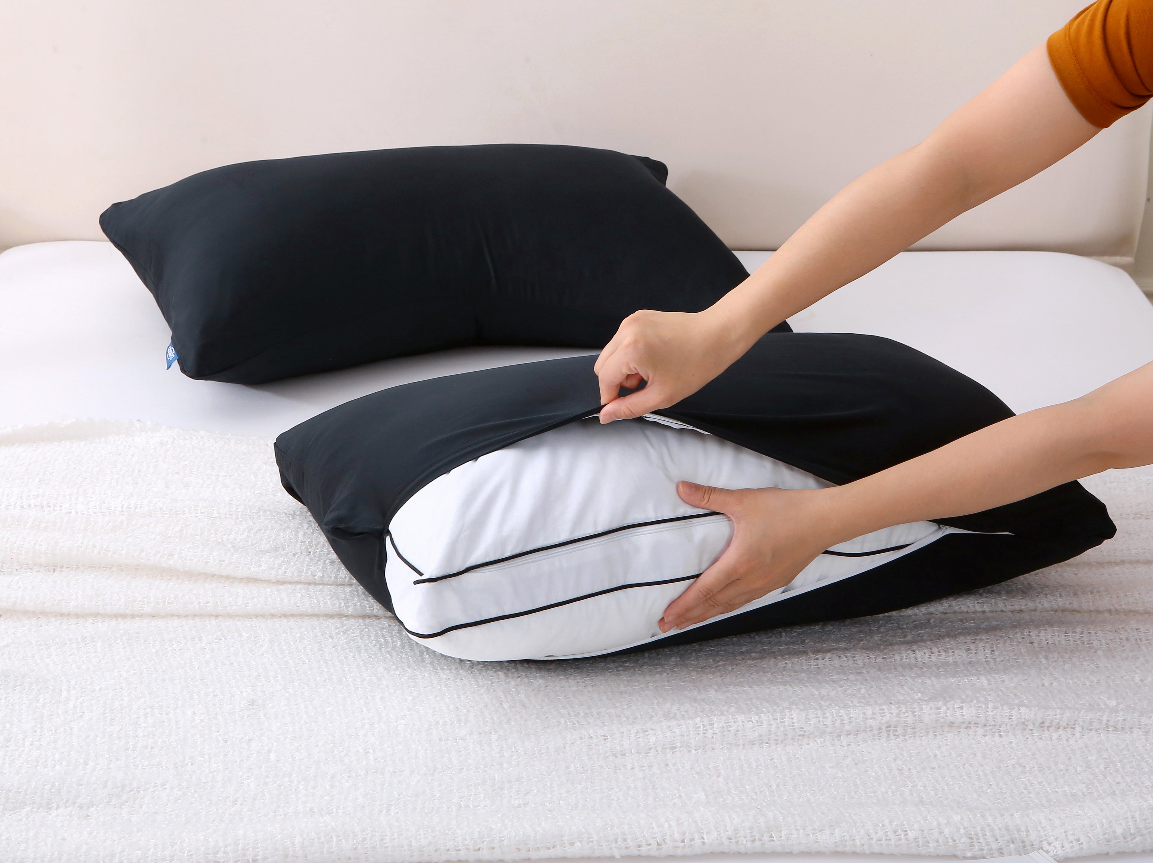 Cushyz bamboo cooling black pillow covers on pillows arranged on a neatly made bed for a sleek, modern look.