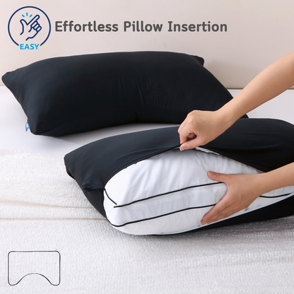 Person inserting a pillow into a black Cushyz bamboo cooling pillow cover on a bed, featuring a wide side opening for effortless pillow insertion and secure fit, labeled “EASY”.