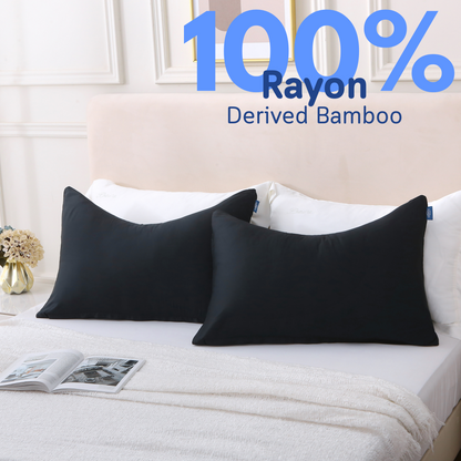 Two pillows in black Cushyz curved bamboo cooling pillow covers are neatly placed on a bed, labeled 100% rayon derived from bamboo.