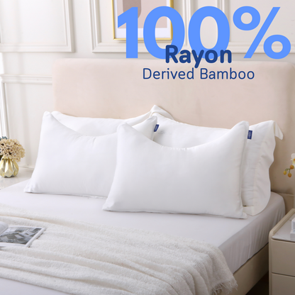 Two pillows in white Cushyz curved bamboo cooling pillow covers are neatly placed on a bed, labeled 100% rayon derived from bamboo.
